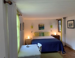 Een slaapkamer met een bed, nachtkastjes, een bureau en een stoel.