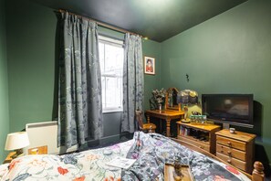 Cozy retreat with a comfortable bed, dresser, and desk, offering a peaceful space to unwind.