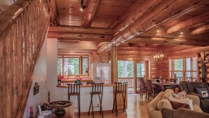 A rustic cabin interior with a kitchen, dining area, and living room.