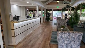 A reception area with a reception desk, seating area, and a view of the outside. - Papakea Paradise, G102, 2 Bedroom & 2 Bathroom, Ground Level, Air Con, Specials! (Lahaina)