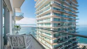 Um edifício moderno de vários andares com varandas com vista para a praia.