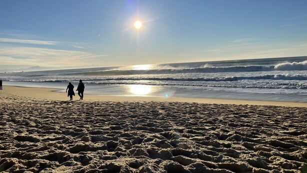 A beach with footprints leading to the water, a clear sky, and the sun low on the horizon. - Apartment T3 with terrace, 100 m from the beach and 5 min by bike from the lake (Soorts-Hossegor)