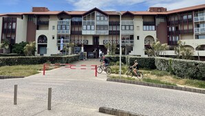 A multi-story building with a central entrance, balconies, and a gated driveway. - Apartment T3 with terrace, 100 m from the beach and 5 min by bike from the lake (Soorts-Hossegor)