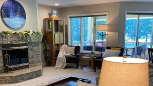 Un salon avec une cheminée, un canapé, une table basse et une lampe.