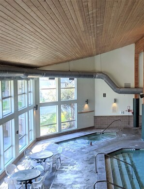 A spa area with a hot tub, seating, and large windows. - 2 Bdrm Condo w/Golf Course view, 5 min. to Lake Wenatchee, Leavenworth, XC ski (Leavenworth)