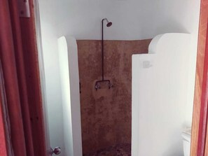 A small, enclosed shower area with a single showerhead, a visible water control valve, and a textured wall. - Hotel Jardín Mahahual (Mahahual)