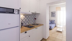 A compact kitchen with white cabinets, a wooden countertop, and a built-in sink. - Casa Alameda Cadiz Centro (Cádiz)