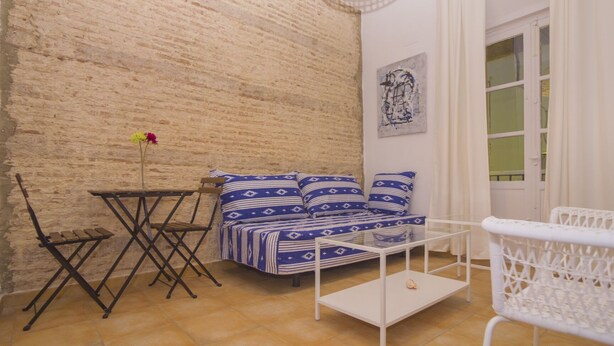 A cozy living room with a sofa, a small table, and a chair. - Casa Alameda Cadiz Centro (Cádiz)