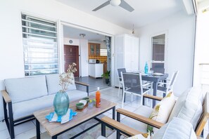 A bright living area with a sofa, coffee table, and dining table set up.
