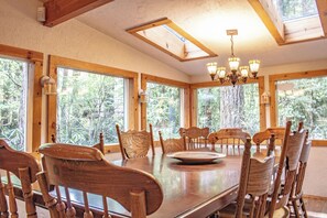 A dining area with a large wooden table, multiple chairs, and a chandelier. - Escape to Magical "Minikahda Lodge" on Clear Creek in Rhododendron (Rhododendron)