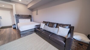 A modern bedroom with a bed, a leather sofa, and a large mirror. - Slopeside 2762 (Keystone)