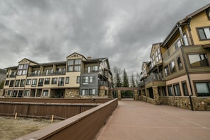 A multi-story residential building with balconies, a stone facade, and a paved courtyard.