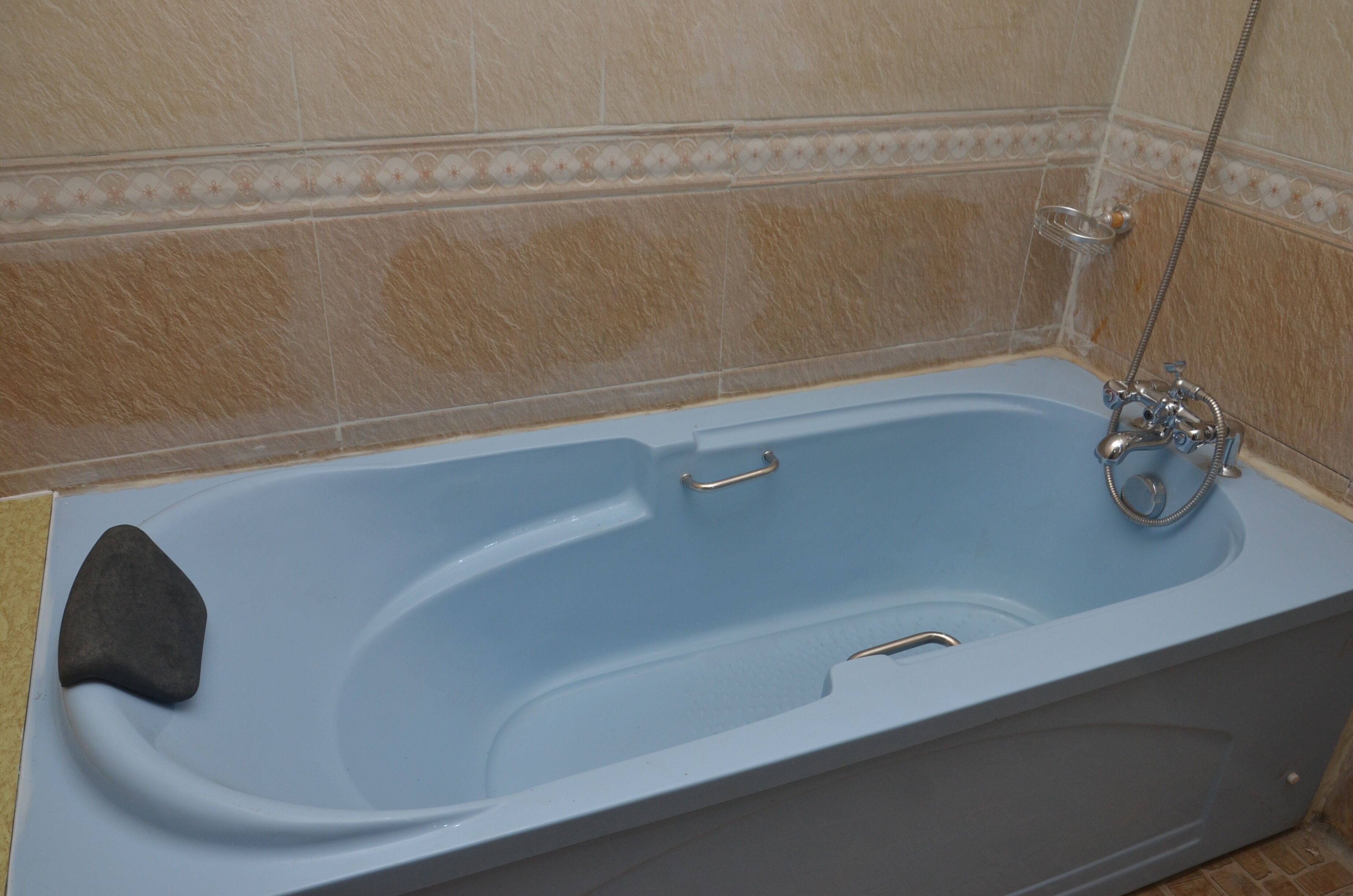 A bathroom with a bathtub, a shower, and a towel rack.