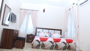 Un dormitorio con una cama, un armario de madera, una mesita y un espejo.