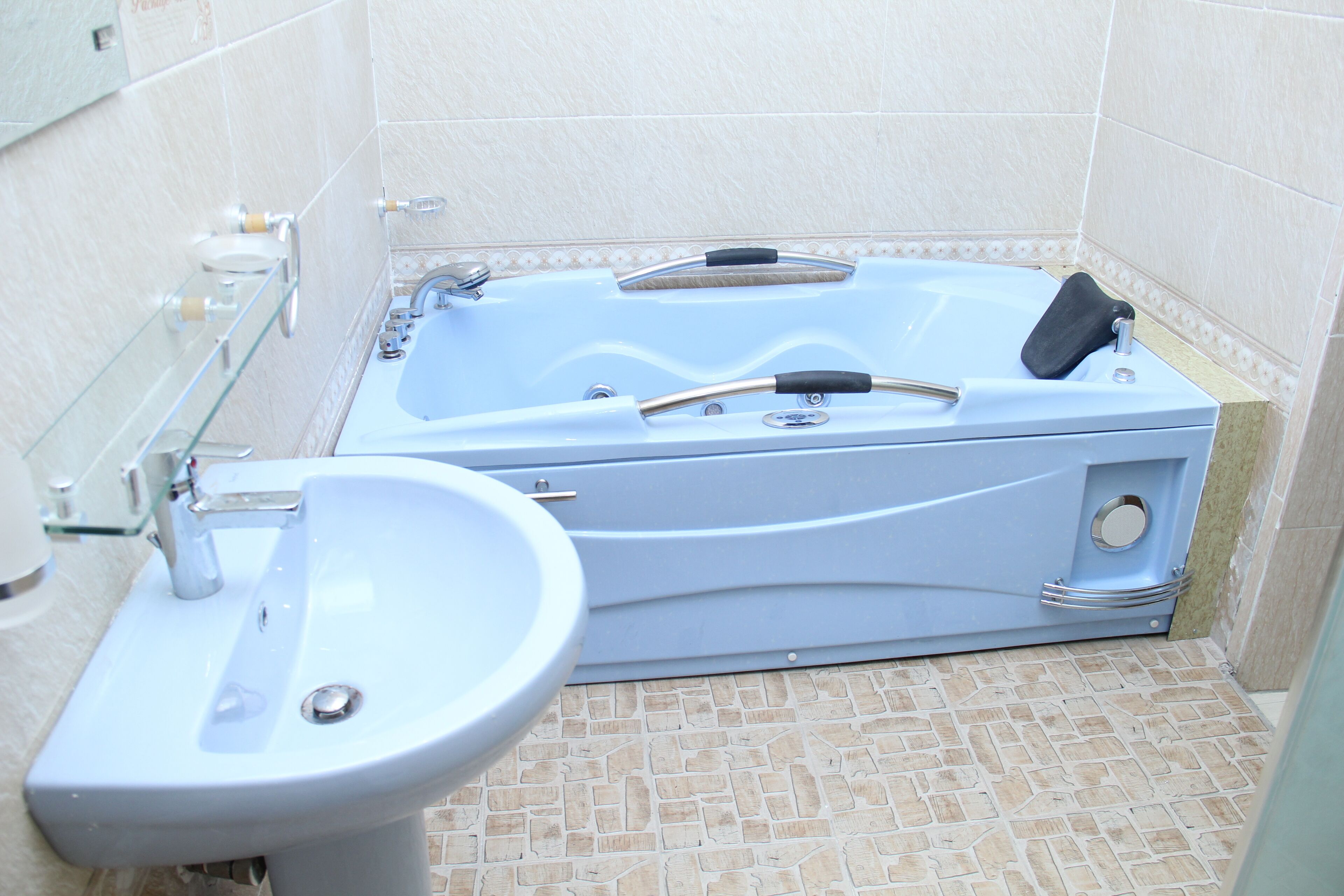 A bathroom with a bathtub, a sink, and a glass shower enclosure.