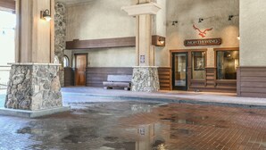 A reception area with a stone pillar, wooden bench, and a sign reading "NORTH WING". - Red Hawk Lodge 2241 OFB (Keystone)