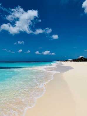 Una playa con agua turquesa cristalina y arena blanca.