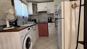 Cocina compacta con lavadora, microondas y refrigerador.