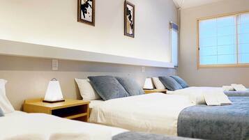 A hotel room with two beds, a large window, and artwork on the walls.