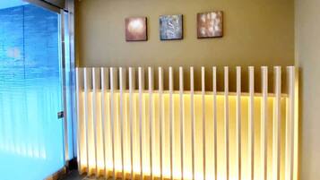 Una habitación con puerta de vidrio, un radiador y tres obras de arte en la pared.