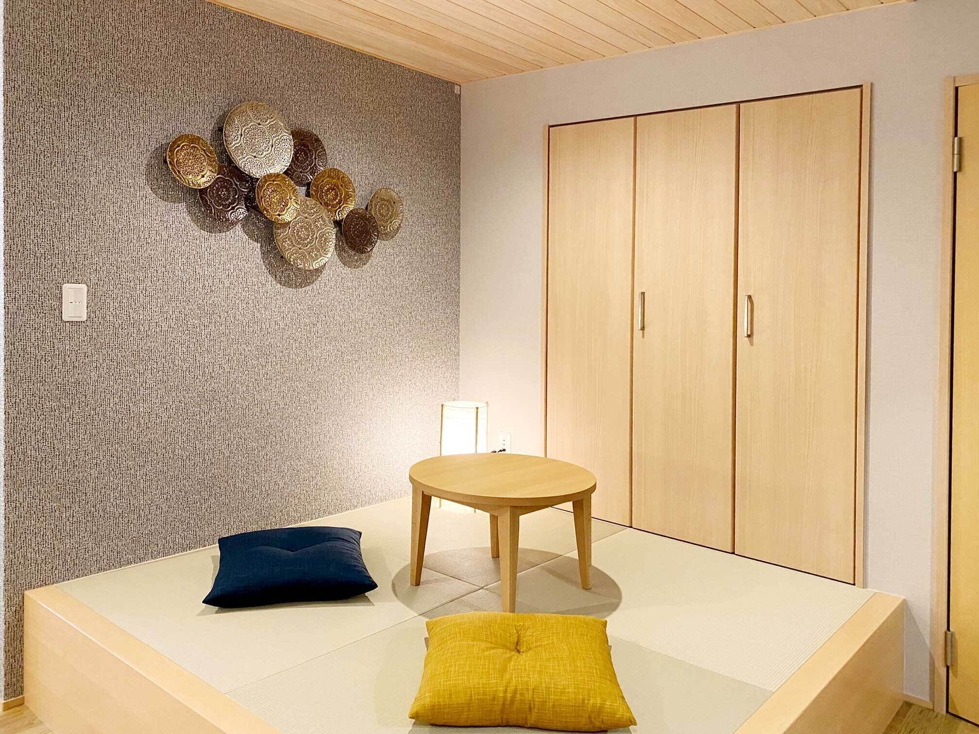 A room with a bed, a round wooden table, and a wardrobe.