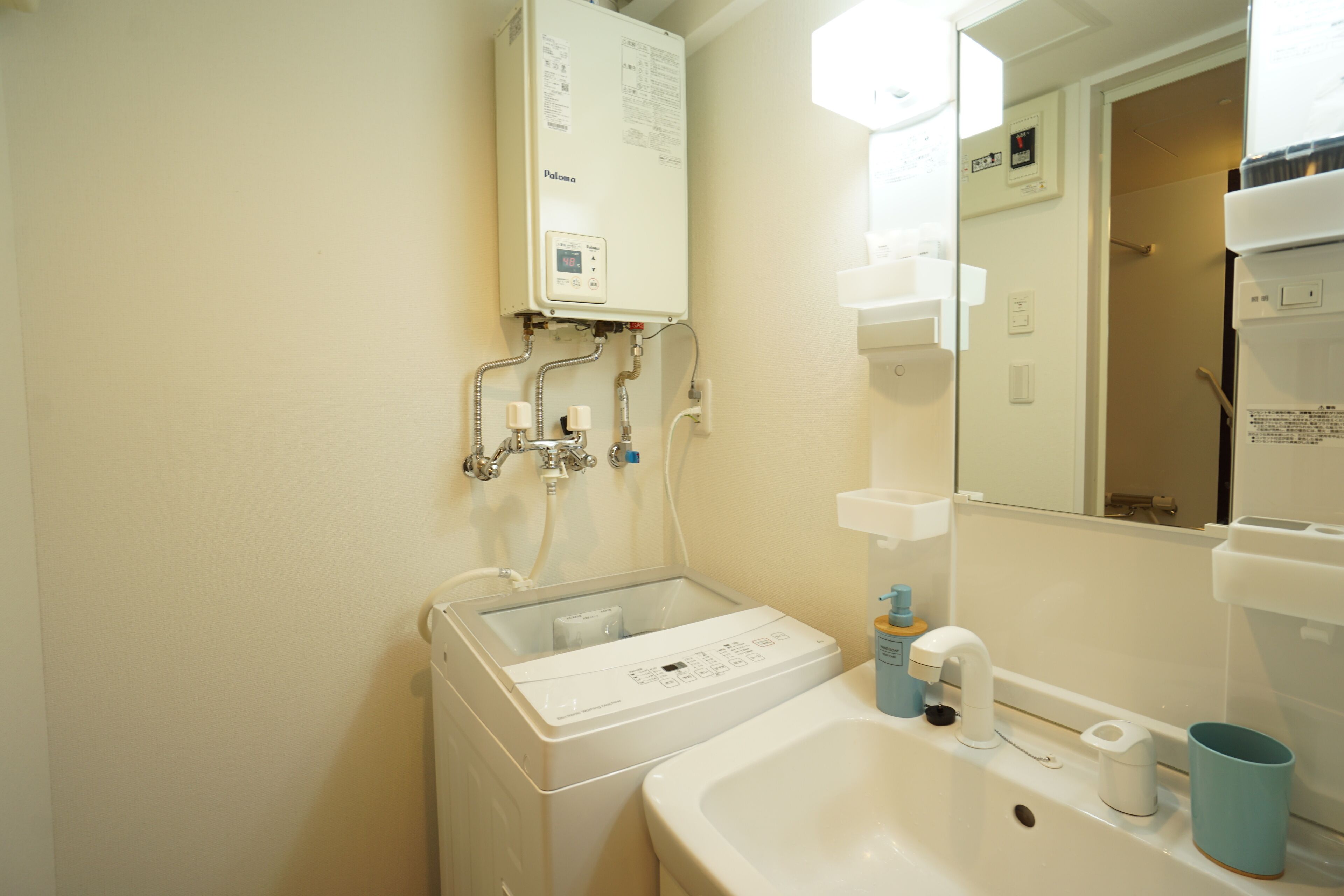 Une salle de bain avec un lavabo blanc, un miroir, un porte-serviettes et un radiateur fixé au mur.
