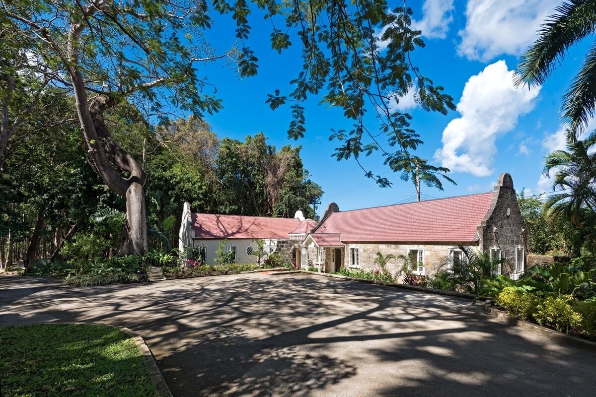 A building with a red roof, surrounded by lush greenery and trees.