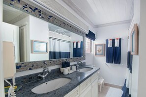 A bathroom with two sinks, a large mirror, and a tiled backsplash.