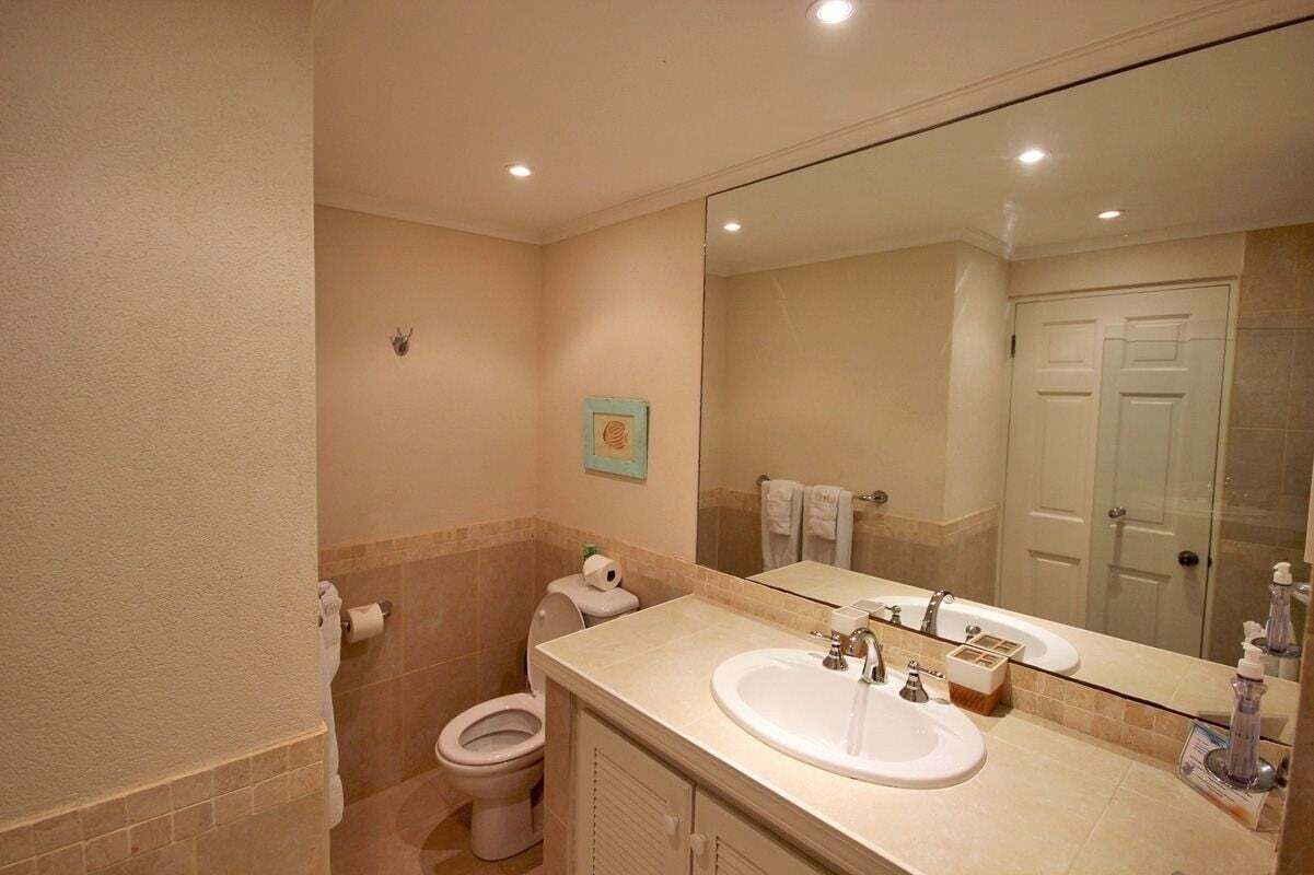 Ein Badezimmer mit Toilette, Waschbecken und Spiegel.
