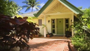 A house with a green door, a covered porch, and a tiled driveway. - Jessamine by Blue Sky Luxury (Gibbes)