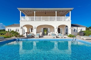 A two-story building with a swimming pool in front.