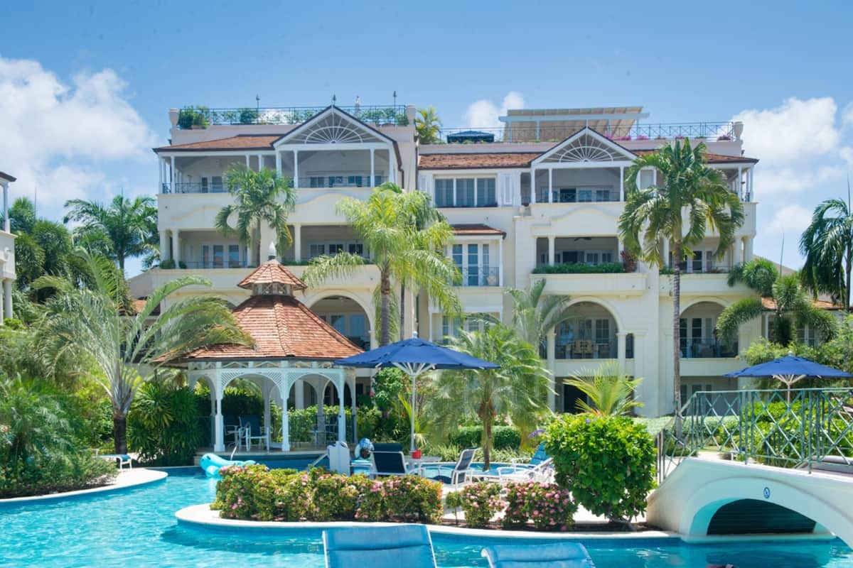 Ein Resort mit großem Pool, Palmen und einem Pavillon.