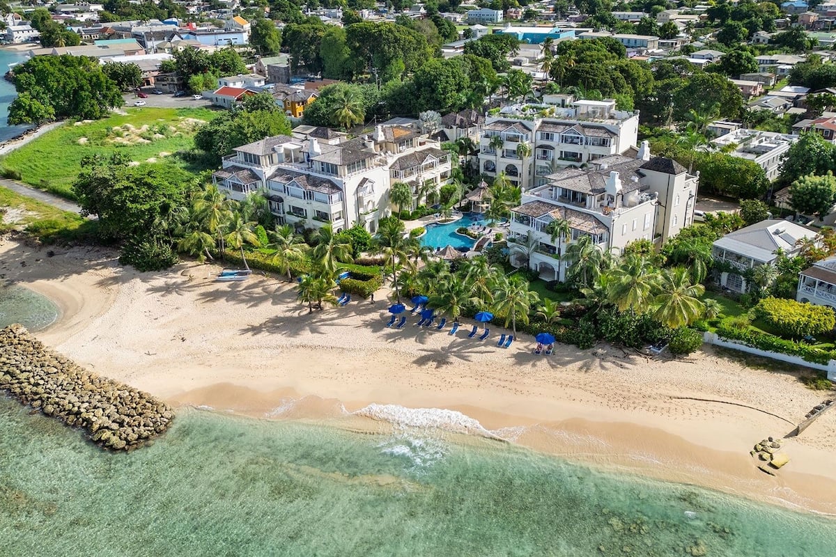 Ein Küstenresort mit Strandvillen, einem Pool und üppiger Vegetation.
