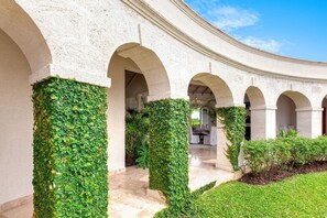 A building with a curved facade, multiple arches, and greenery covering the columns. - Marsh Mellow by Blue Sky Luxury (Weston)