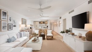 Una sala de estar moderna con un sofá blanco, una mesa de centro y un comedor con sillas y una mesa.