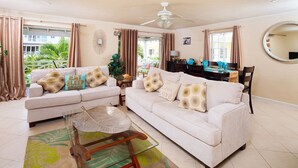 A living room with two sofas, a glass coffee table, and a dining area with a table and chairs. - Margate Gardens 4 by Blue Sky Luxury (Hastings)