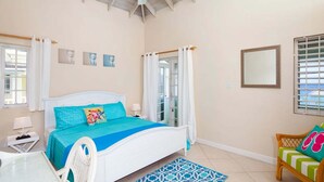 A bedroom with a bed, a chair, a table, and a window. - Margate Gardens 4 by Blue Sky Luxury (Hastings)