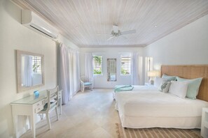 A bedroom with a bed, a desk, and a chair.