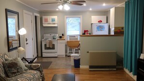A compact living space with a kitchenette, a dining area, and a seating area.