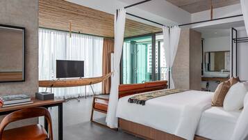 Una habitación de hotel moderna con una cama grande, un escritorio con televisor y vistas a la ciudad a través de amplios ventanales.