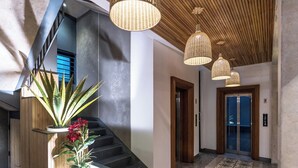 Ein modernes Interieur mit Treppe, Holzvertäfelung und einem gemusterten Boden.