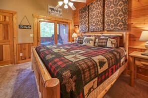 Un dormitorio de madera con una cama grande, un ventilador de techo y un letrero de bienvenida.