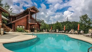 Un edificio de estilo cabaña de madera con zona de piscina.