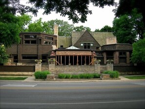 Un grand immeuble à étages, doté d’une façade en pierre remarquable et d’un toit triangulaire distinctif.