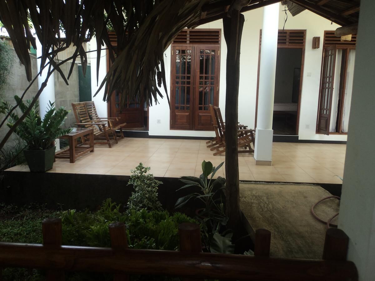 A covered outdoor area with wooden furniture and potted plants.