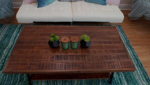 A wooden coffee table with three hexagonal planters, a white sofa with blue cushions, and a green and blue striped rug. - 🔥WALK 2 BEACH❤️ | SLEEPS 6 W/ W+D (Biloxi)