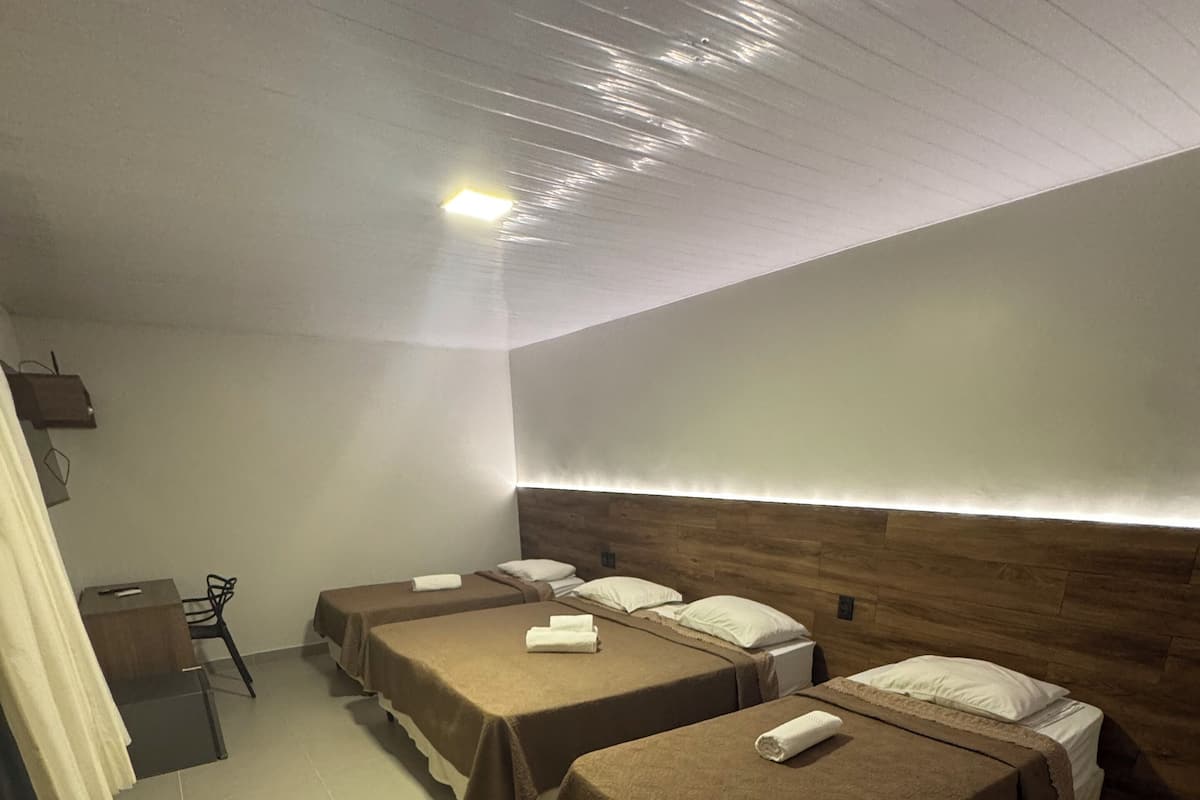 Ein Hotelzimmer mit zwei Betten, einem Schreibtisch und einem Sessel.