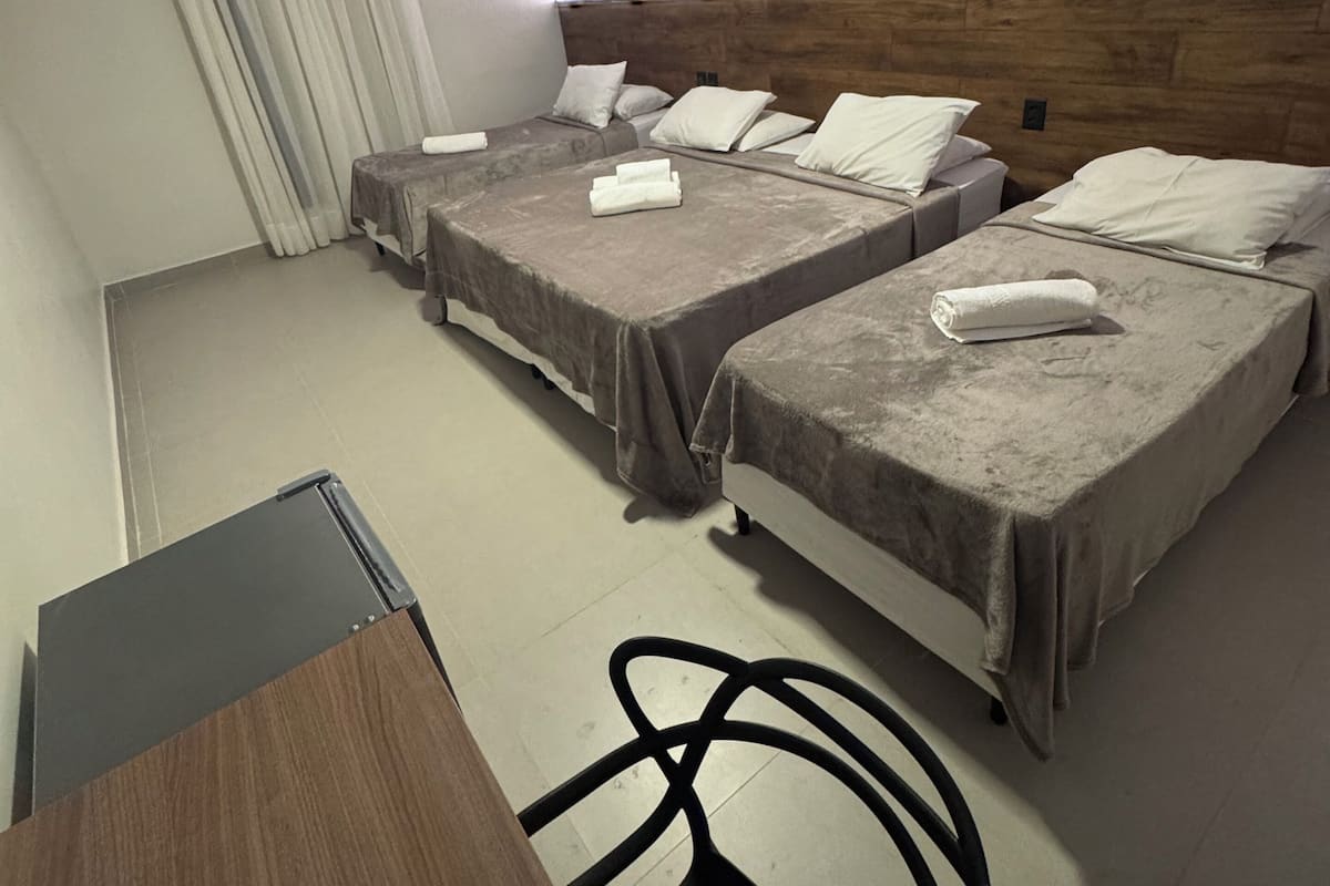 Ein Hotelzimmer mit zwei Betten, einem Schreibtisch und einem Stuhl.