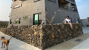 A modern multi-story building with a stone foundation and balconies. - Green House Homestay (Magong)