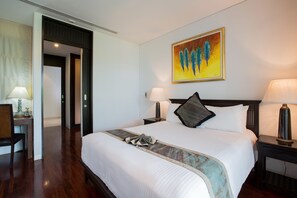 A hotel room with a large bed, two bedside tables with lamps, a painting on the wall, and a door leading to another room.